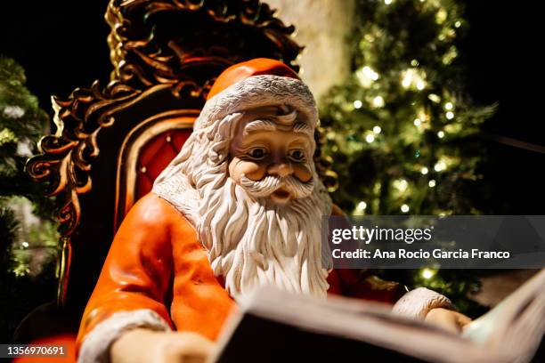 santa claus statue reading a book - santa throne stock pictures, royalty-free photos & images