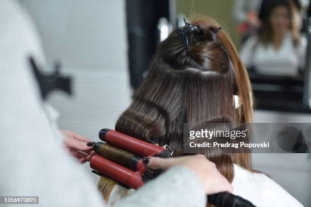 hairstyle with curling tongs - fer à friser photos et images de collection