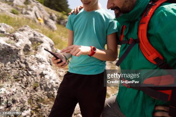 unrecognizable father and son orientate with a help of mobile gps app - lost generation stock pictures, royalty-free photos & images