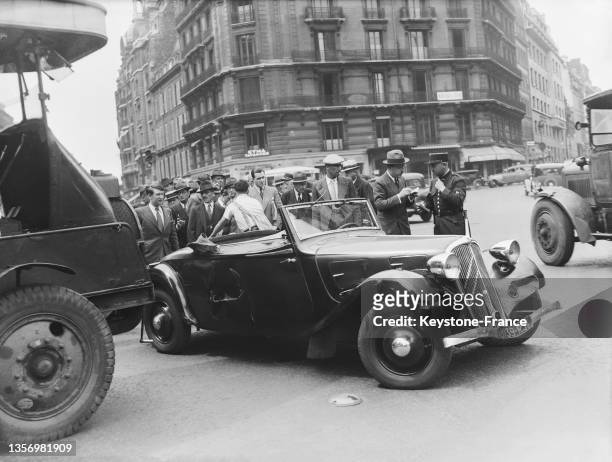 Policier contrôlant le constat après une collision en un bus et une voiture à Paris, le 19 juillet 1937.