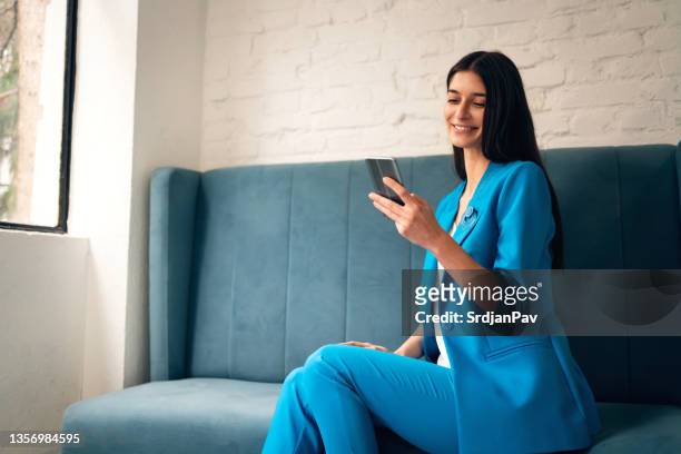 happy modern young woman, using mobile phone for online purchase - blue suit stock pictures, royalty-free photos & images