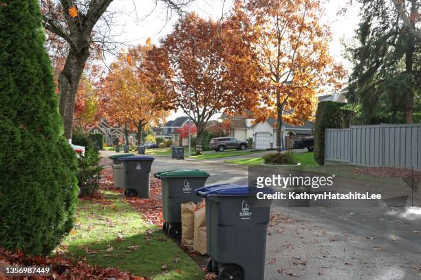 recycling and organic bins on collection day in a vancouver suburb - surrey wagons stock pictures, royalty-free photos & images