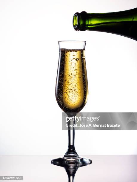 bottle filling a glass of champagne on a white background - glass half full party stock pictures, royalty-free photos & images