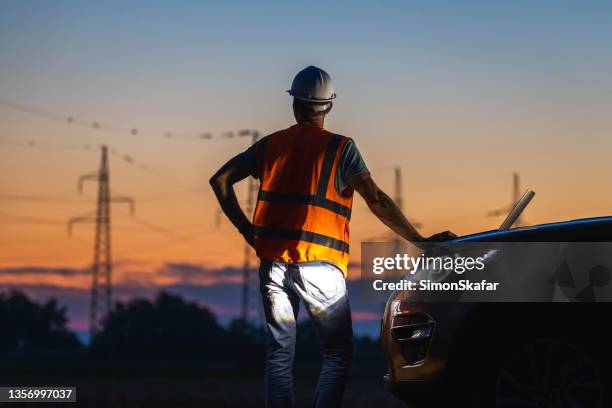 engineer facing towards high voltage poles - power grid stock pictures, royalty-free photos & images