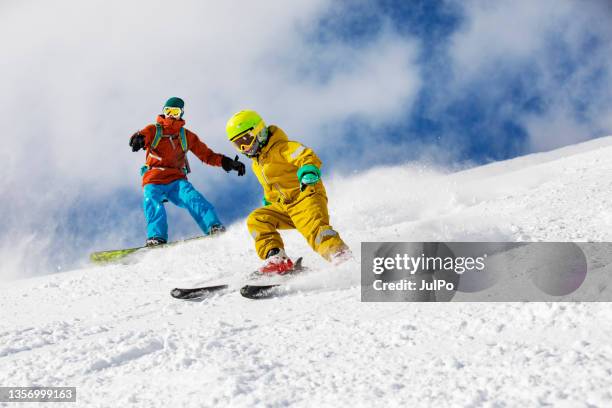 father and son skiing in mountains - family skiing stock pictures, royalty-free photos & images