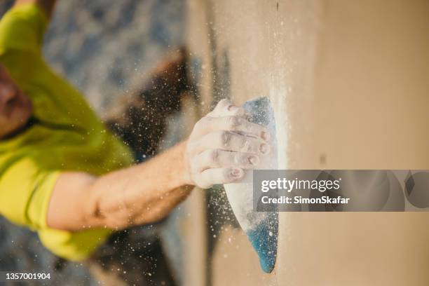 powder flying of climber mans hands while grabbing bouldering wall handle - rope handle stock pictures, royalty-free photos & images