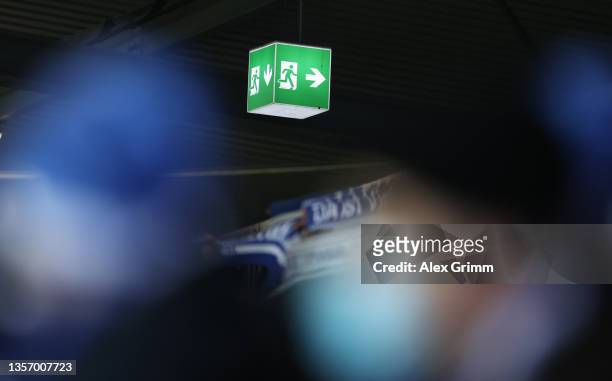 An exit sign is pictured between fans wearing face masks before new rules limiting or banning fans due to the corona pandemic come into force after...