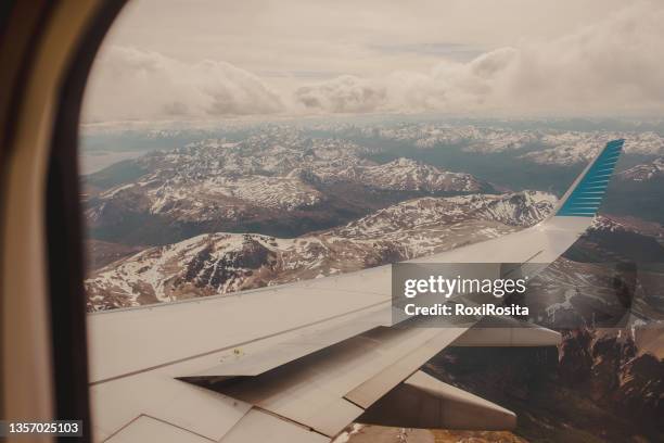 wing of an airplane over the snowy mountain range. the andes, argentina - anden stock-fotos und bilder