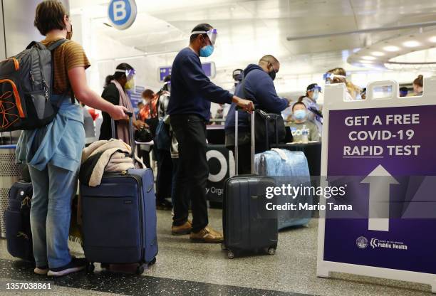 People who arrived on international flights wait to be tested on the first day of a new rapid COVID-19 testing site for arriving international...