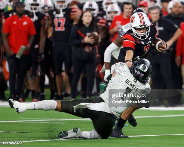 Quarterback Cameron Rising of the Utah Utes avoids a tackle by linebacker Noah Sewell of the Oregon Ducks on a rush during the Pac-12 Conference...