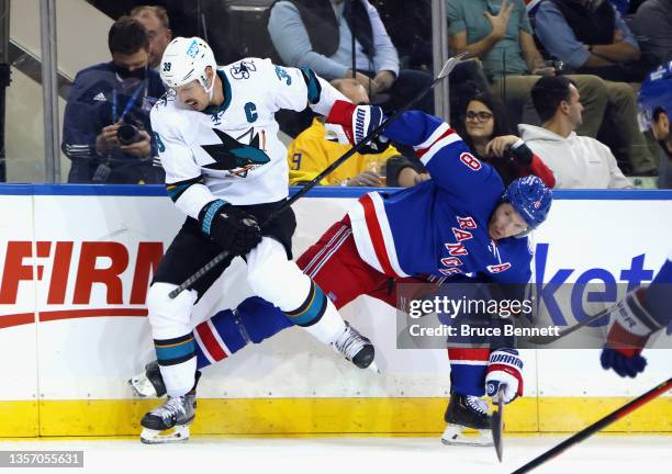 Jacob Trouba of the New York Rangers collides with Logan Couture of the San Jose Sharks at Madison Square Garden on December 03, 2021 in New York...