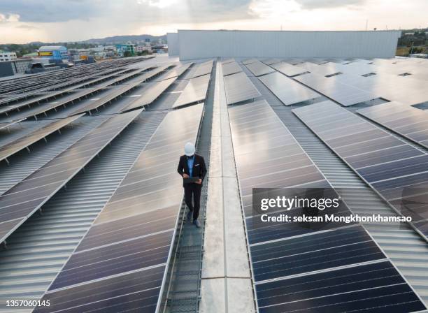 electrical engineers are using laptops to monitor the operation of the solar rooftop. renewable energy concepts. - roof replacement stock pictures, royalty-free photos & images