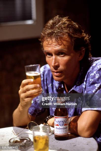 American film and stage actor Peter Weller drinks a Budweiser on set during the 1989 drama film "Cat Chaser" circa 1989 in San Juan, Puerto Rico.