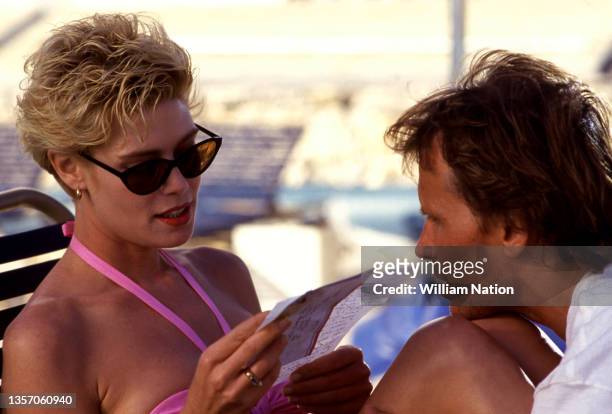American stage and screen actress Kelly McGillis talks with American film and stage actor Peter Weller on the set of the 1989 drama film "Cat Chaser"...