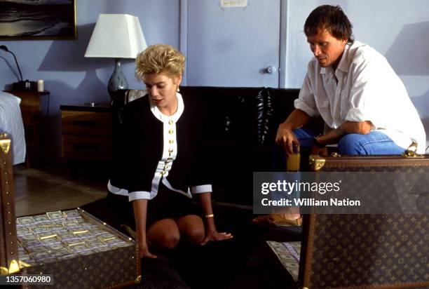 American stage and screen actress Kelly McGillis and American film and stage actor Peter Weller film a scene with a suitcase full of money during the...