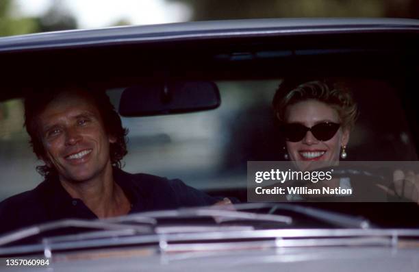 American film and stage actor Peter Weller and American stage and screen actress Kelly McGillis film a scene while driving in a car during the 1989...