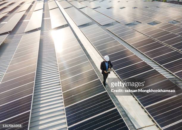 high angle view of solar power plant engineers and examining photovoltaic panels - solar panel city stock-fotos und bilder