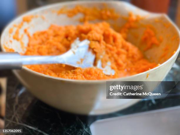 preparing traditional sweet potato casserole topped with marshmallows for family holiday dinner - mashed sweet potato stock-fotos und bilder