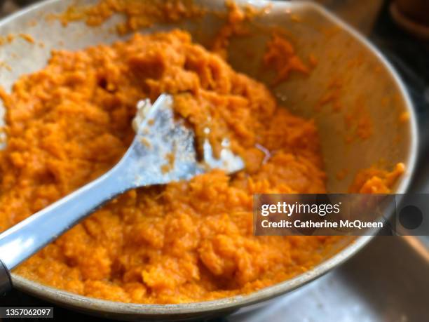 preparing traditional sweet potato casserole topped with marshmallows for family holiday dinner - mashed sweet potato stock-fotos und bilder