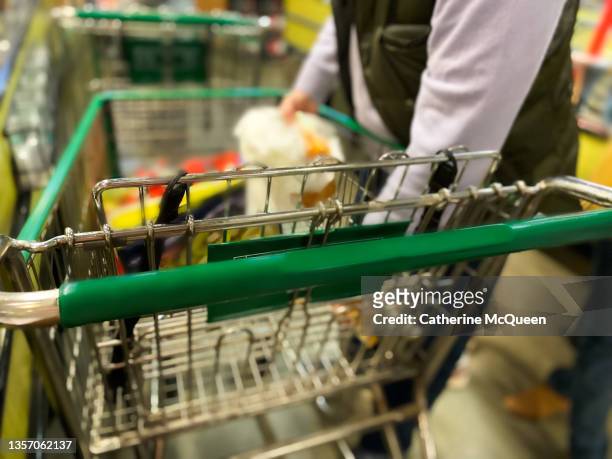 dad unloading groceries at checkout counter for purchase - inflation stock-fotos und bilder