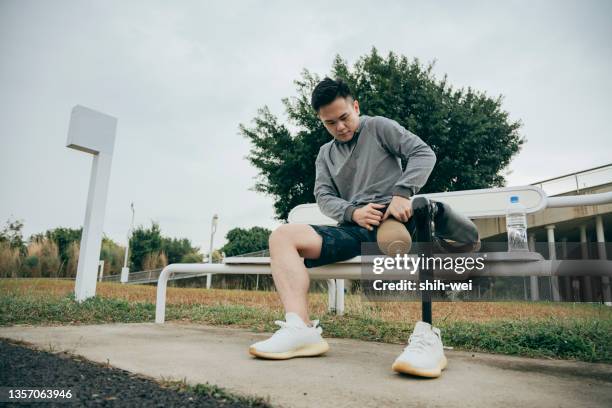 sporty taiwanese man attaching a sports limb to his stub - artificial limb stock pictures, royalty-free photos & images