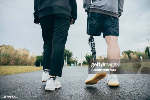 friends walking in the park - artificial limb stockfoto's en -beelden