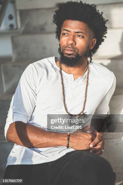 cool young black guy with natural hair in candid casual portrait on cement city staircase - necklace stock pictures, royalty-free photos & images