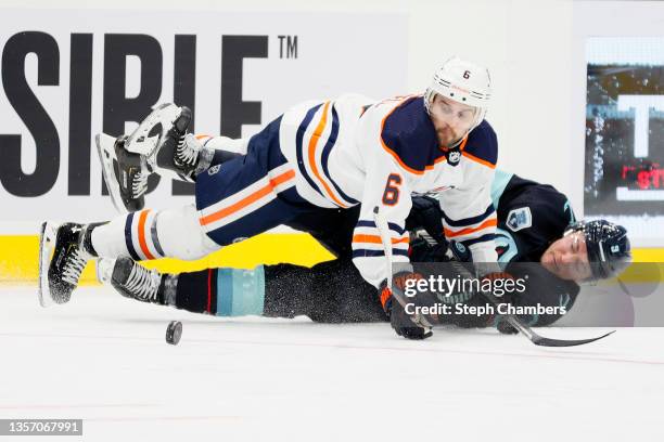 Kris Russell of the Edmonton Oilers and Ryan Donato of the Seattle Kraken collide as they chase the puck during the third period at Climate Pledge...