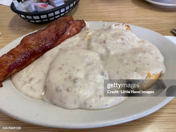 sausage gravy biscuits and bacon - buttermilk biscuit stock-fotos und bilder