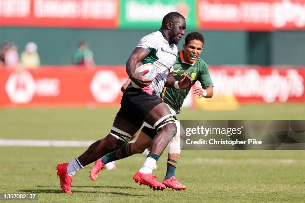 Herman Humwa of Kenya runs with the ball past Ronald Brown of South Africa during the Men’s Cup Quarterfinal match between South Africa and Kenya on...