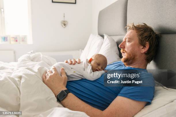 newborn baby asleep on father's chest - wirkliches leben stock-fotos und bilder