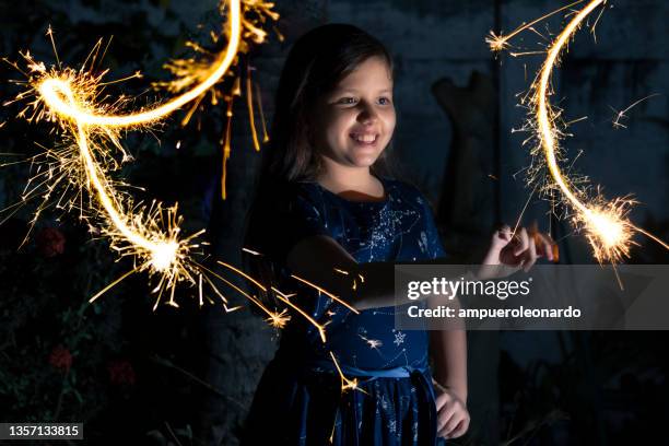 young latin little girl outside celebrating new year's or christmas holidays playing with sparkles fireworks at ecuador, latin america.

ecuador popular traditions at new year's eve. - fire sprinkler stockfoto's en -beelden