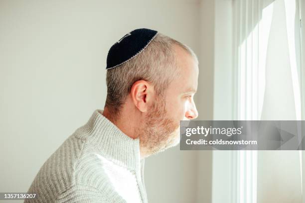 jewish man wearing skull cap at home - hasidic clothing stock pictures, royalty-free photos & images