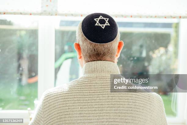 jüdischer mann mit totenkopfmütze zu hause - judenstern stock-fotos und bilder