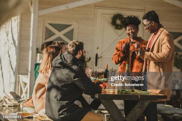 group of friends hanging out in warm autumnal sunshine in the back yard - house warming stock pictures, royalty-free photos & images
