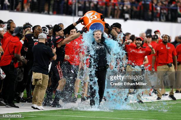 Defensive end Mika Tafua and defensive tackle Devin Kaufusi of the Utah Utes dump Gatorade on their head coach Kyle Whittingham late in the Pac-12...