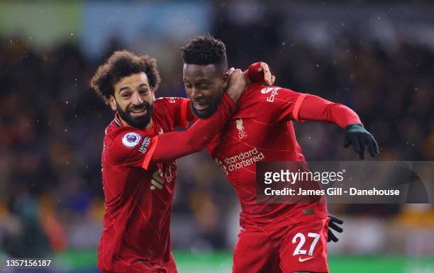 Divock Origi of Liverpool celebrates with Mohamed Salah after scoring the winning goal during the Premier League match between Wolverhampton...