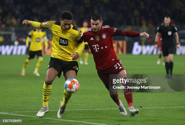 Lucas Hernández of Muenchen is challenged by Jude Bellingham of Dortmund during the Bundesliga match between Borussia Dortmund and FC Bayern München...