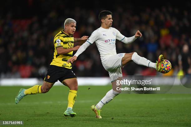 Joao Cancelo of Manchester City passes the ball whilst under pressure from Cucho Hernandez of Watford FC during the Premier League match between...