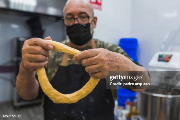 pastry chef stretching roscon de reyes dough inside a pastry shop - roscon de reyes 個照片及圖片檔