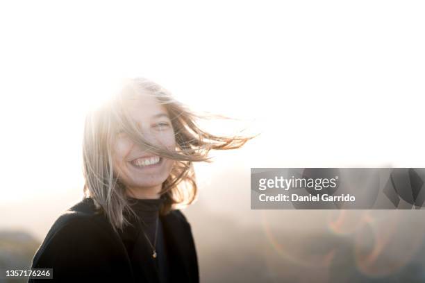 blonde girl enjoying life, lifestyle, smiling, sunset and wind - hair blowing stockfoto's en -beelden