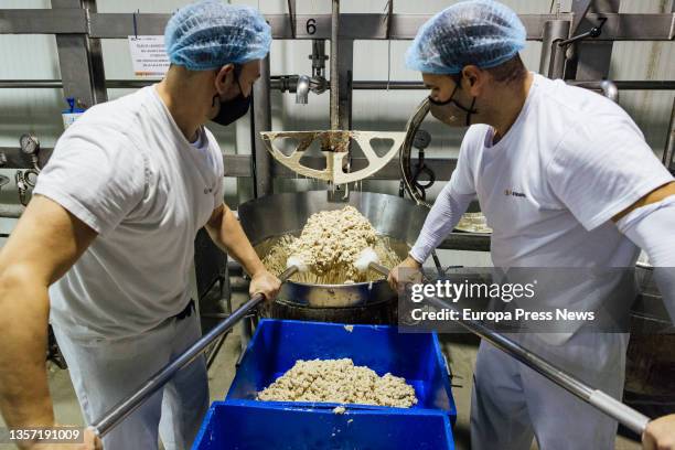 Two workers of 'El Artesano' elaborate the turron dough during a guided tour of the facilities of the turron factory 'El Artesano', on November 30,...