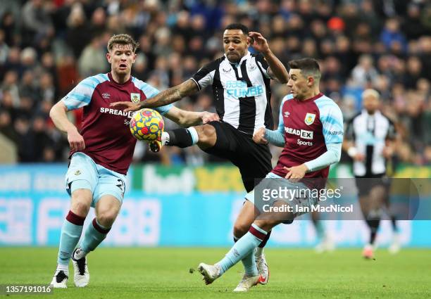 Callum Wilson of Newcastle United evades Nathan Collins and Matthew Lowton of Burnley during the Premier League match between Newcastle United and...