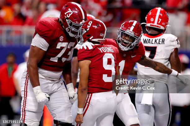 Bryce Young of the Alabama Crimson Tide reacts after scoring a touchdown with teammate Evan Neal in the second quarter of the SEC Championship game...