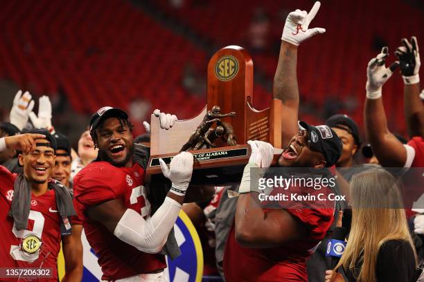 Will Anderson Jr. #31 of the and Phidarian Mathis of the Alabama Crimson Tide hold up the SEC Championship trophy at the conclusion of the game...