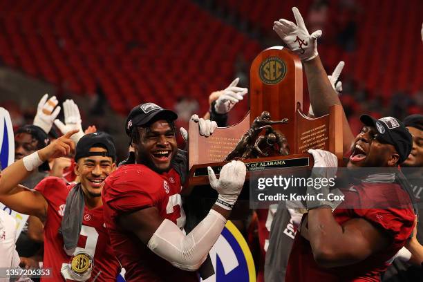 Will Anderson Jr. #31 of the and Phidarian Mathis of the Alabama Crimson Tide hold up the SEC Championship trophy at the conclusion of the game...