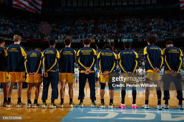 The Michigan Wolverines stand for the national anthem, wearing social justices messages on their warmups, before a game against the North Carolina...
