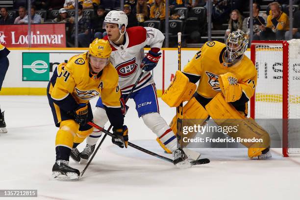 Mikael Granlund of the Nashville Predators vies with Jake Evans of the Montreal Canadiens for position in front of goalie Juuse Saros during the...