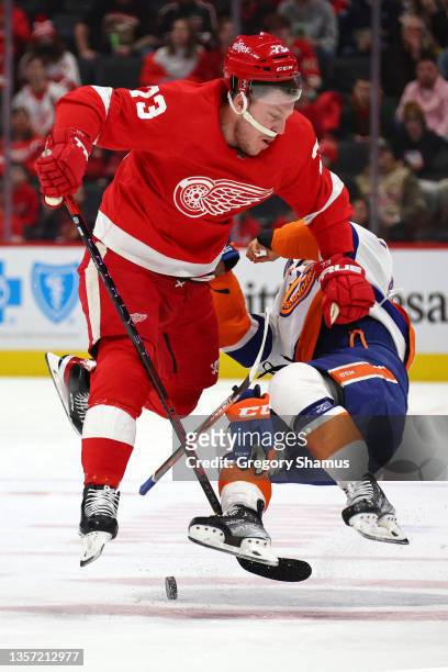 Adam Erne of the Detroit Red Wings lays a big hit on Anthony Beauvillier of the New York Islanders during the first period at Little Caesars Arena on...