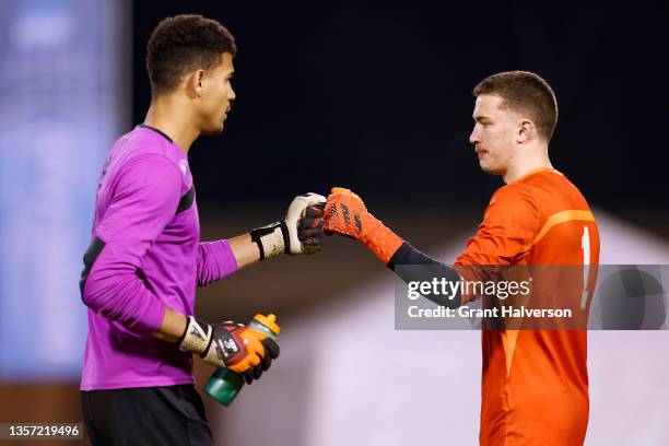 Kofi Hope-Gund of the Amherst Mammoths fist-bumps Sam Maidenberg of the Connecticut College Camels before the start of penalty kicks to decide the...